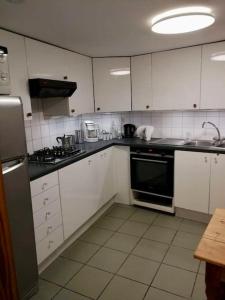 a kitchen with white cabinets and a black appliance at Triplex près de la Grand-Place in Brussels