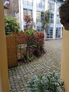 a brick courtyard with a fence and a building at Triplex près de la Grand-Place in Brussels