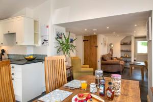 cocina y sala de estar con mesa, cocina y comedor. en North Beer Cottage, en Launceston