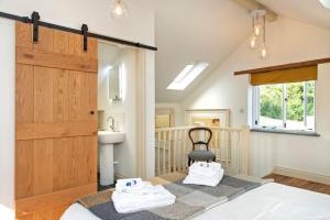 1 dormitorio con cama, lavabo y ventana en North Beer Cottage, en Launceston