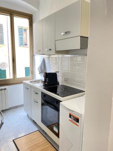 a kitchen with white cabinets and a stove top oven at Paolina Home in La Spezia