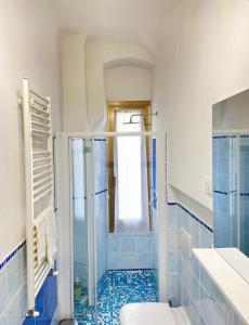 a bathroom with a shower and a toilet and blue tiles at Paolina Home in La Spezia