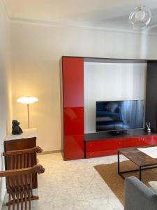a living room with a tv and a red entertainment center at Paolina Home in La Spezia