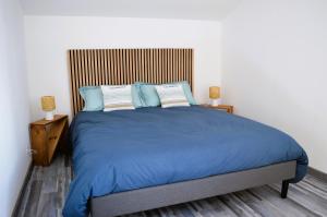 - une chambre avec un grand lit bleu et deux lampes dans l'établissement La Guillaumière - Maison avec bel extérieur, à Cresserons