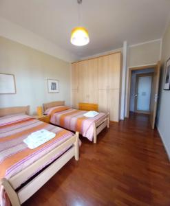 2 camas en una habitación con suelo de madera en Le Stanze di Nonna Lina en Pagani