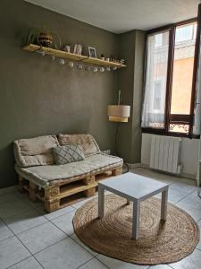a living room with a couch and a table at studio cosy plein coeur de ville in Gap