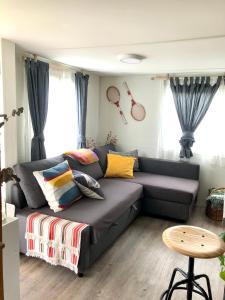 a living room with a gray couch with colorful pillows at Xilloi Playa in O Vicedo