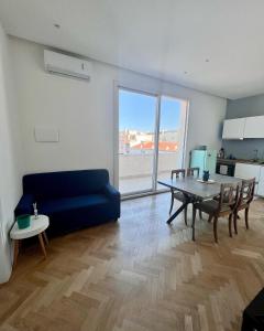 een woonkamer met een blauwe bank en een tafel bij Ermes Apartment - Historic Centre Catania in Catania