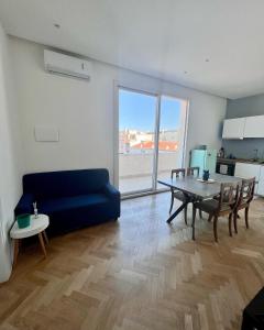 salon z niebieską kanapą i stołem w obiekcie Ermes Apartment - Historic Centre Catania w Katanii