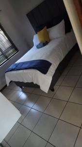 a bed sitting on a tiled floor in a bedroom at Stunning Golf Course view in Roodepoort