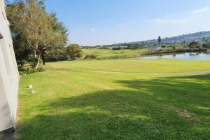 a view of a golf course with a body of water at Stunning Golf Course view in Roodepoort