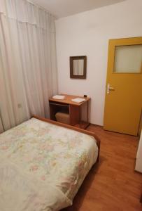 een slaapkamer met een bed, een bureau en een deur bij Гарсониера in Stara Zagora