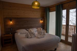 - une chambre avec un lit et des serviettes dans l'établissement Les Cèdres - Hôtel - Restaurants - Spa, à Saint-Sorlin-dʼArves