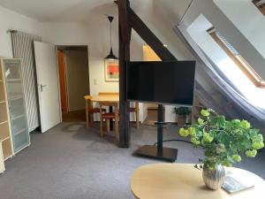 sala de estar con TV y mesa en Ferienwohnung Brunnenhaus, en Bad Sassendorf