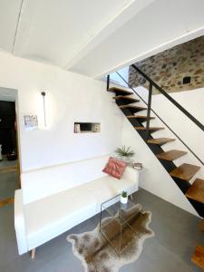 uma sala de estar com um sofá branco e escadas em La Martela de Fuentes Casa de diseño rural em Fuentes de León