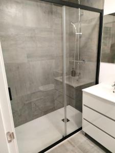 La salle de bains est pourvue d'une douche avec une porte en verre. dans l'établissement APTO BAHIA SUR RESERVA DE CONFIANZA, à San Fernando
