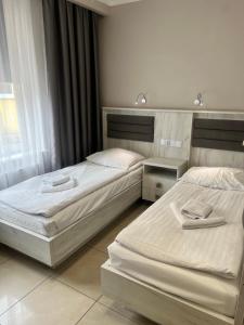 2 Betten in einem Hotelzimmer mit Röcken in der Unterkunft Rodos in Jaczów
