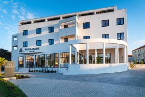 a large white building with a sign in front of it at Miramare Hotel in Zadar