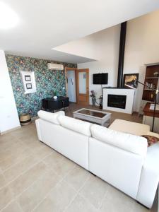 a living room with a white couch and a tv at La Martela de Segura Apartamento rural piscina in Segura de León