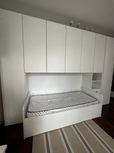 a white cabinet with a bed in a room at Tevere 20 House in Monza