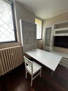 a white desk and a chair in a room at Tevere 20 House in Monza