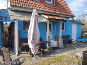 un parapluie assis devant une maison bleue dans l'établissement Ferienhaus Dünenhaus, à Dierhagen 24 autres photos