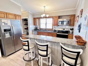 cocina con nevera de acero inoxidable y taburetes en Escape OBX, en Kitty Hawk