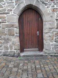 - une grande porte en bois dans un bâtiment en pierre dans l'établissement iSABELLE, à Vannes