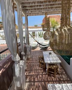 a porch with a table and a view of the beach at Riad Chocolat in Marrakech