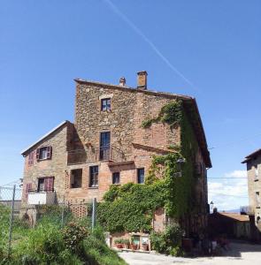 an old stone building with ivy growing on it at CasaVacanza Borgo Cenaioli tra Toscana e Umbria Lago Trasimeno in Sant Arcangelo