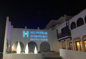 un bâtiment avec un panneau la nuit dans l'établissement Apartamentos Hesperia Bristol Playa, à Corralejo