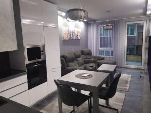 a kitchen and living room with a table and a couch at Апартамент Светли in Vratsa