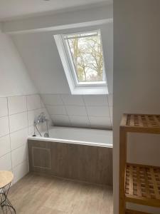 a bathroom with a bath tub and a window at Ferienwohnung Horst 2 in Nordenham