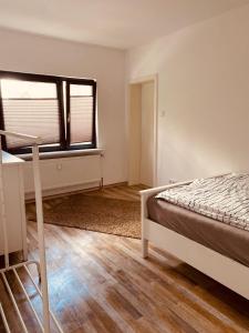 an empty bedroom with a bed and a window at Ferienwohnung Horst 2 in Nordenham