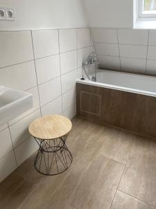 a bathroom with a table and a bath tub at Ferienwohnung Horst 2 in Nordenham +29 photos