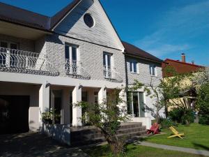 a white house with a gambrel roof at Oti Guesthouse in Tallinn