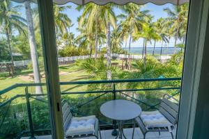 a room with a view of the beach and palm trees at Le Sable d'Or in La Saline les Bains