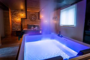 a large bath tub in a room with a bed at Love industrie & spa in Bischoffsheim