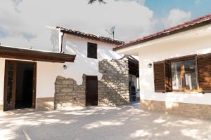 una casa bianca con un muro di pietra di B&B Tenuta Piano Campo a Ucria
