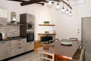 cocina con mesa de madera y comedor en B&B Tenuta Piano Campo en Ucria