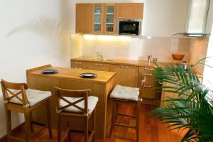 a kitchen with a wooden island with chairs and a sink at Abbesses Montmartre Apartment in Paris