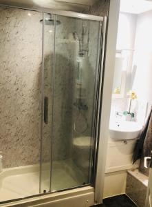 a shower with a glass door next to a sink at Holloway House in Bath