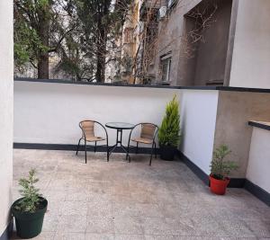 a patio with two chairs and a table and some plants at Victory in Stara Zagora