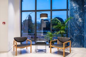 two chairs and a table in a room with windows at Miramare Hotel in Zadar +37 photos