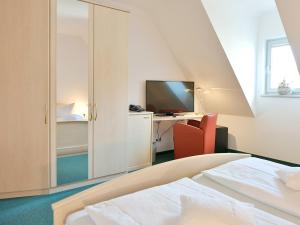 een slaapkamer met een bed en een bureau met een televisie bij Haus Hufeland in Bad Salzungen