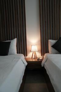 two beds in a room with a lamp on a table at EXEN BY WEEKEND in Bodrum City