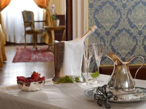 a table with a silver tea kettle and a bowl of strawberries at Hotel Corte dei Greci in Venice