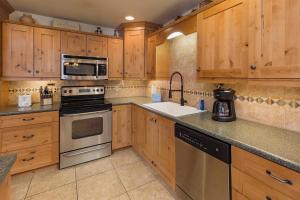 eine Küche mit Holzschränken und einem Herd mit Backofen in der Unterkunft Sitzmark 12 in Durango Mountain Resort