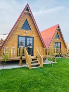 a large wooden house with a large deck at NOEL BUNGALOV & CAFE in Demre