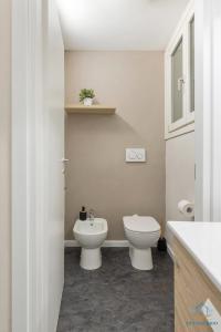 biała łazienka z toaletą i umywalką w obiekcie Appartamento Piccolo Nido w mieście Cannobio